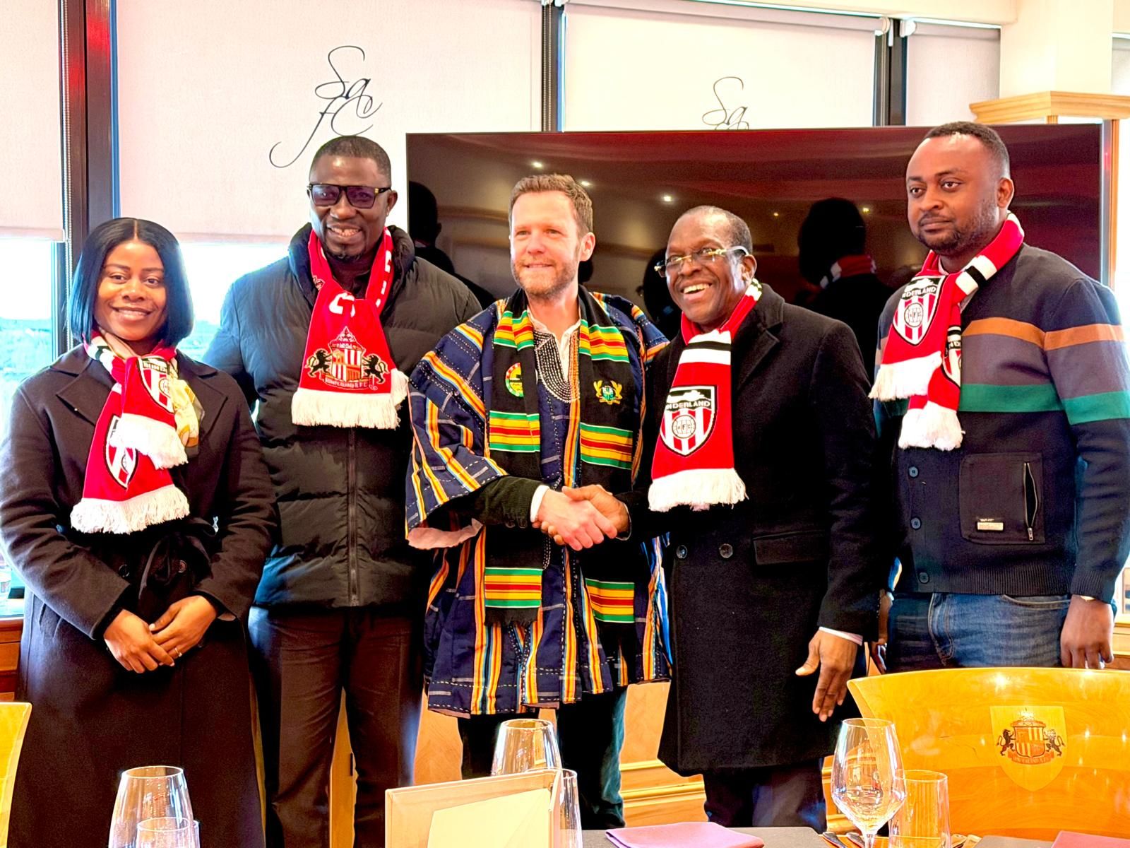 Group photo with hosts in kente and scarves
